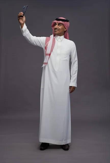 Saudi Man in Traditional Thobe Taking Smartphone Selfie