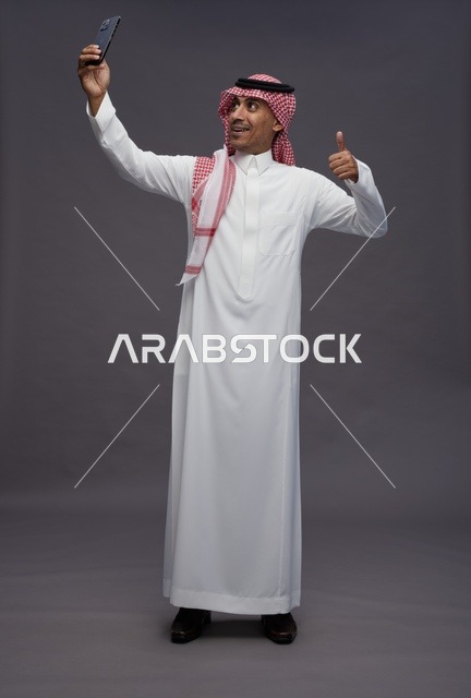 Saudi Man in Thobe Taking Selfie with Thumbs Up