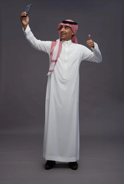 Saudi Man in Thobe Taking Selfie with Thumbs Up