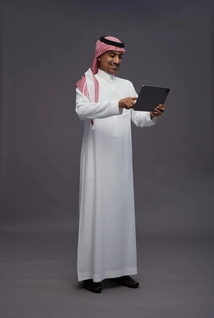 Saudi Man Using Digital Tablet in Traditional Dress