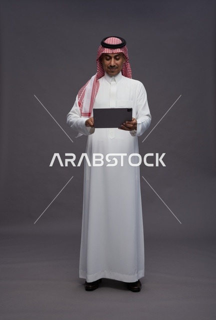 رجل سعودي يستخدم جهاز لوحي في الاستوديو