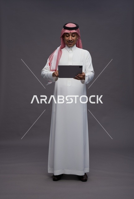 Saudi Man in Traditional Dress Using Tablet Studio