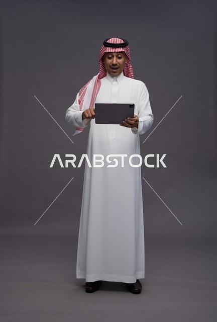 Surprised Saudi Man Using Tablet in Studio Setting