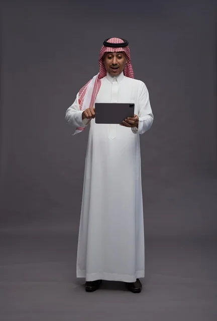 Surprised Saudi Man Using Tablet in Studio Setting