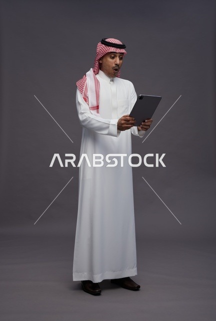 Saudi Man Surprised Looking at Tablet in Studio