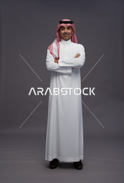 رجل سعودي بالثوب التقليدي على خلفية رمادية