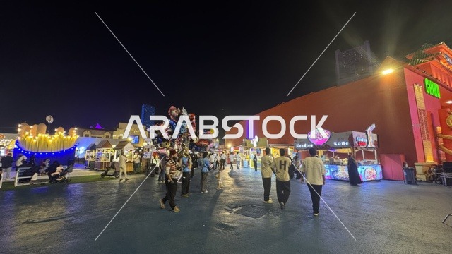 Food stalls in the Global Street of Winter Wonderland Jeddah at night.