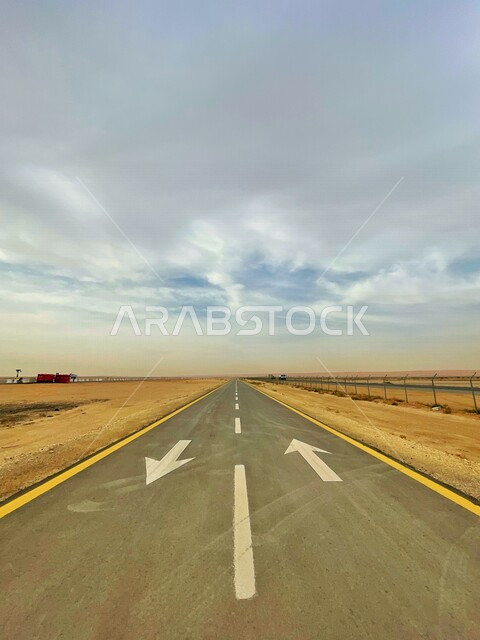 صورة مقربة لطريق اسفلتي واسع، طريق صحراوي، صورة جمالية للسماء المغطاة بالغيوم