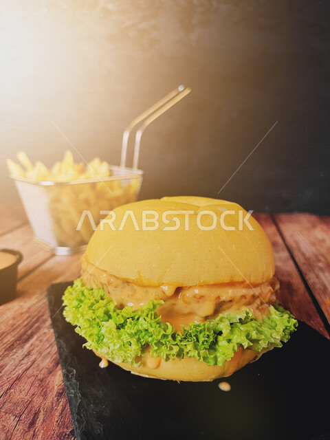 Close-up of a delicious burger sandwich stuffed with meat and cheese with lettuce, ordering a burger meal in the restaurant, serving fast food, delicious meals, Arabic restaurants