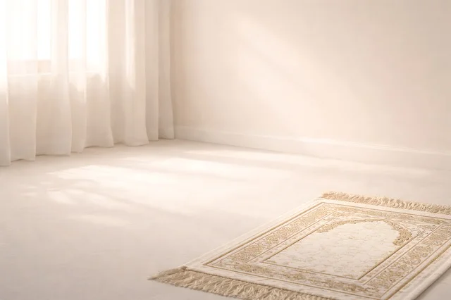 سجادة صلاة في غرفة بيضاء مع إضاءة طبيعية