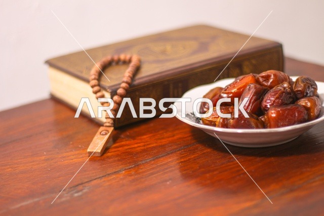 Ramadan Dates with Quran and Prayer Beads on Wooden Table