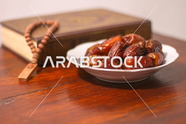 Ramadan Dates Quran and Prayer Beads on Wooden Table