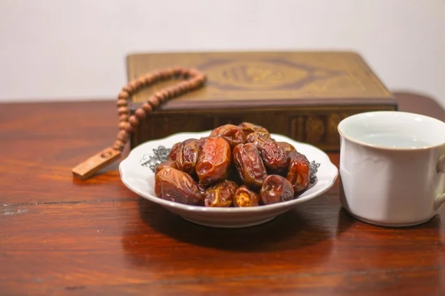 تمر رمضان مع المصحف والسبحة على الطاولة