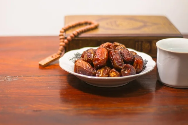 Ramadan Dates with Prayer Beads on Wooden Table