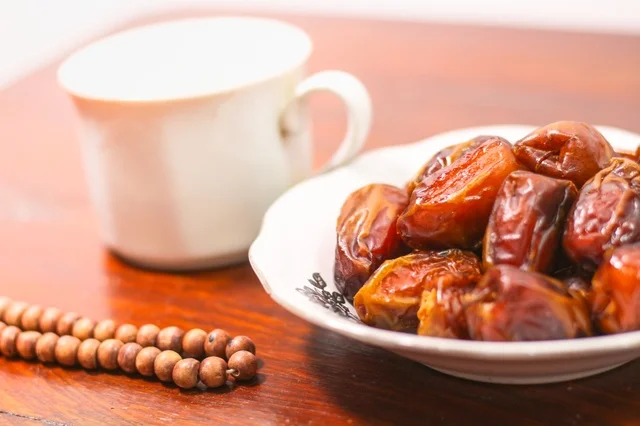Ramadan Dates and Prayer Beads on Dark Wooden Table