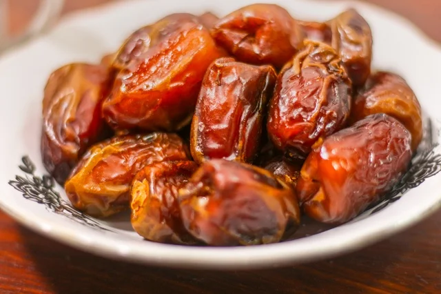 A close-up shot of fresh dates in a white ceramic bowl for Ramadan iftar.