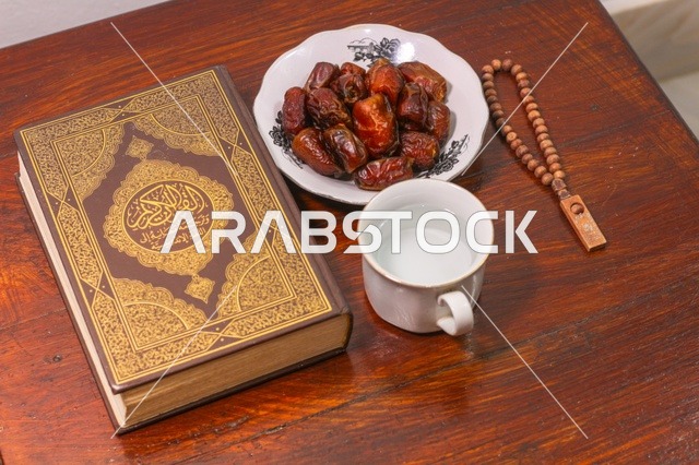 المصحف الشريف والتمر لإفطار رمضان على طاولة خشبية