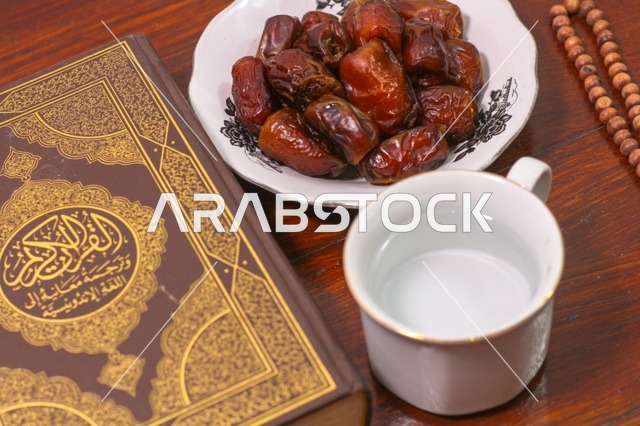 القرآن الكريم مع التمر وكوب ماء للإفطار