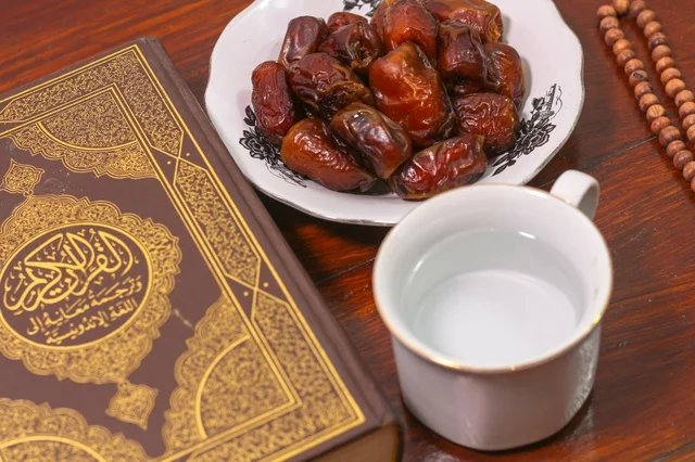 القرآن الكريم مع التمر وكوب ماء للإفطار