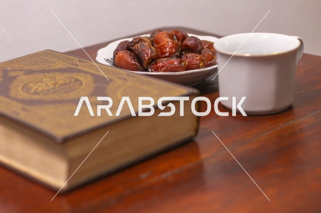 مصحف وتمر على طاولة خشبية في رمضان
