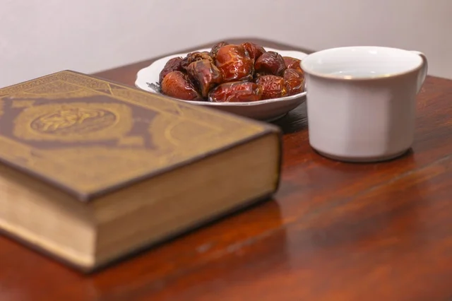 مصحف وتمر على طاولة خشبية في رمضان