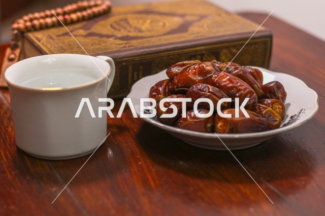تمر رمضان مع المصحف الشريف وكوب ماء للافطار
