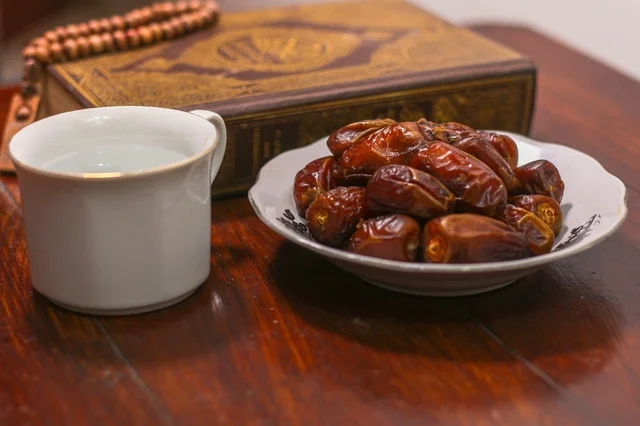تمر رمضان مع المصحف الشريف وكوب ماء للافطار