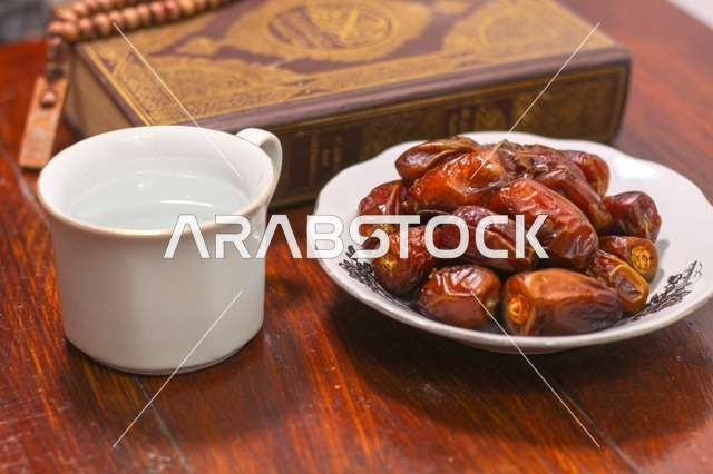 تمر رمضان مع المصحف الشريف وكوب ماء لافطار رمضان