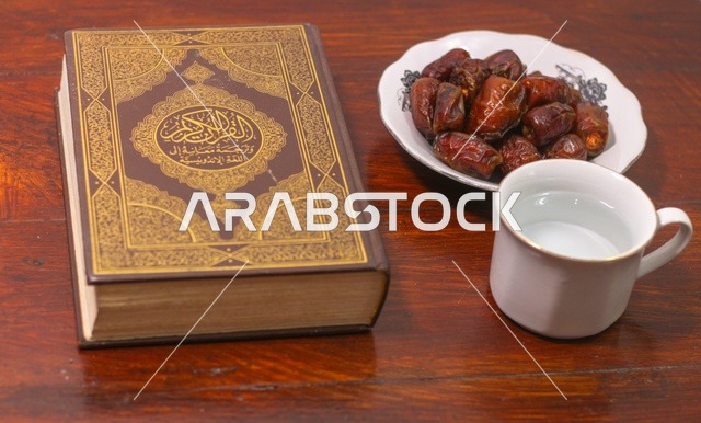 Holy Quran with Dates and Water on Wooden Table