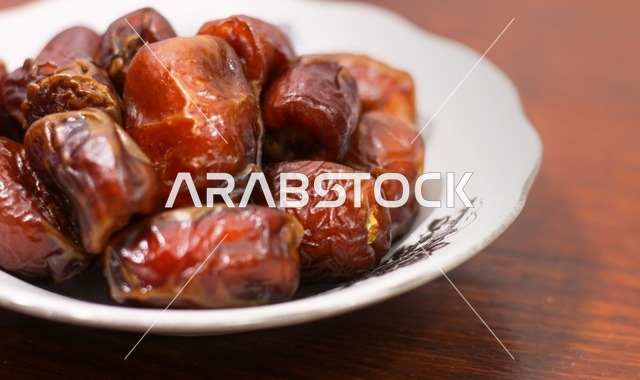 حبات تمر بني في طبق سيراميك لقطة قريبة لافطار رمضان