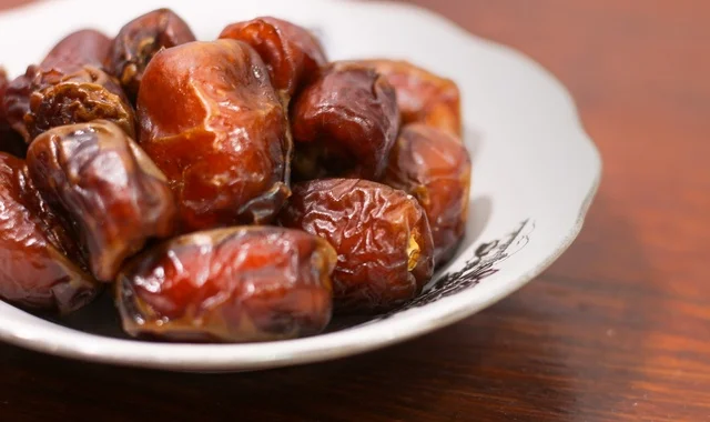 حبات تمر بني في طبق سيراميك لقطة قريبة لافطار رمضان