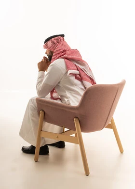 Saudi Man in Traditional Thobe Thinking on Armchair