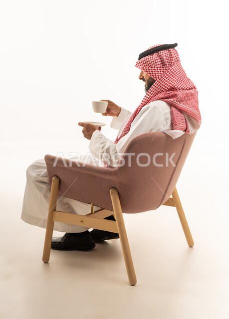 Saudi Man Holding Coffee Cup in Modern Chair