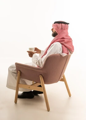 Saudi Man in Traditional Thobe Sitting with Coffee Cup