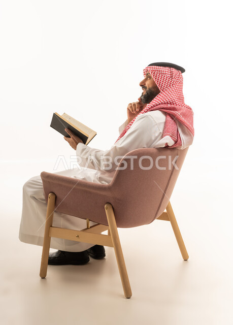 Saudi Man in Traditional Dress Reading Book