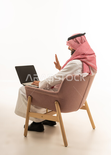 Saudi Man Using Laptop for Video Call on White Background