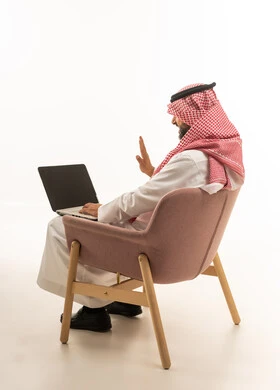 Saudi Man Using Laptop for Video Call on White Background