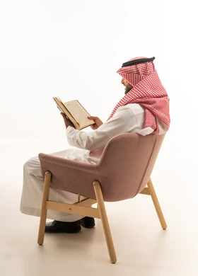 Saudi Man in Traditional Dress Reading a Book
