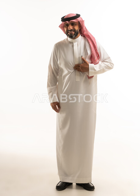 رجل سعودي بالزي التقليدي يضع يده على صدره