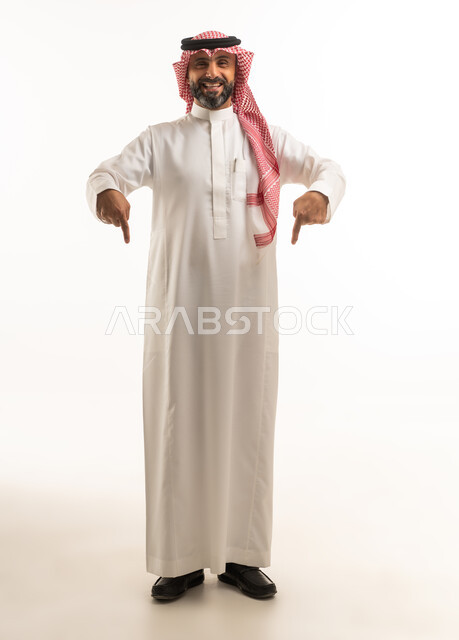 رجل سعودي بالزي التقليدي يشير إلى الأسفل