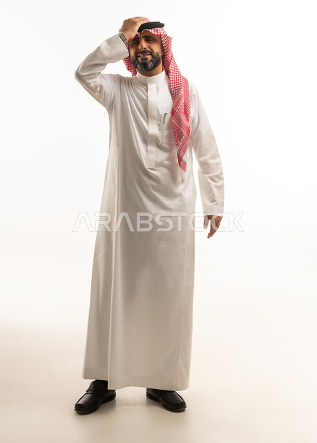 رجل سعودي بالثوب يعبر عن الندم بخلفية بيضاء
