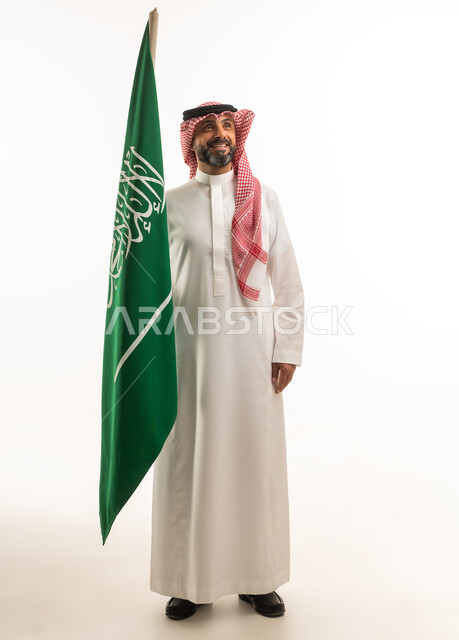 Saudi Man Holding Saudi Arabian Flag in Traditional Dress