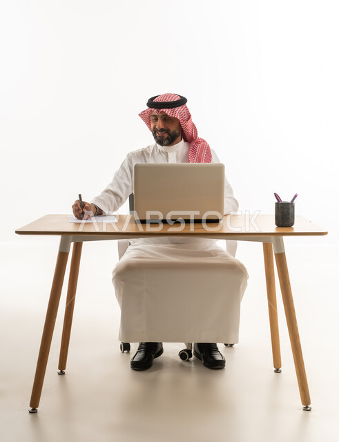 Saudi Businessman Working on Laptop at Desk