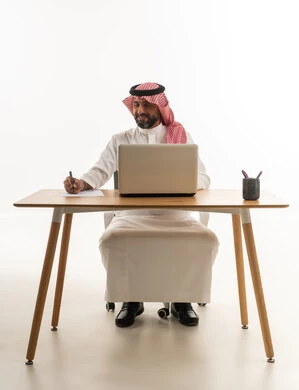 Saudi Businessman Working on Laptop at Desk