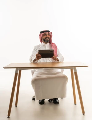 Saudi Man at Desk with Tablet on White Background