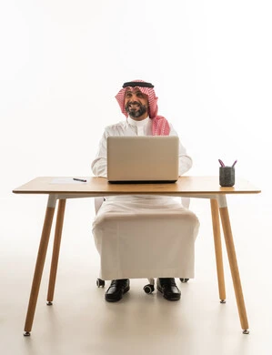 Saudi Businessman at Desk with Laptop on White Background