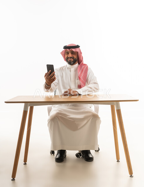 رجل سعودي يستخدم الهاتف الذكي في المكتب