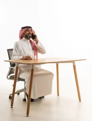 Saudi Man in Traditional Thobe Talking on Phone