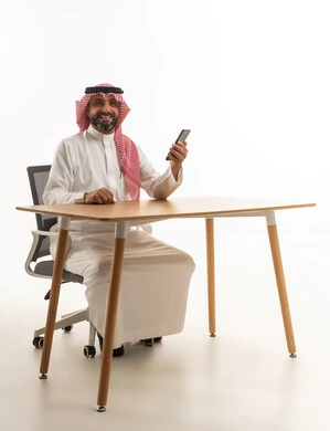 Saudi Businessman at Desk with Smartphone