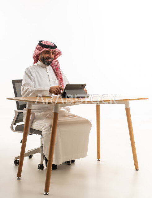 Saudi Businessman Using Digital Tablet at Office Desk